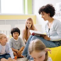 woman reading a book to the children